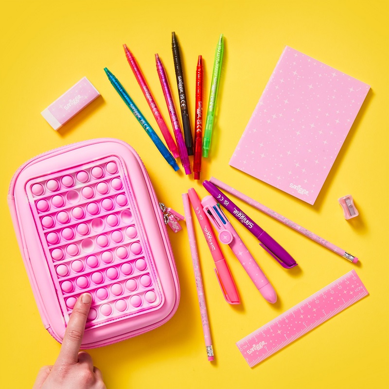 Pink and colourful stationary including a pink popper pencilcase