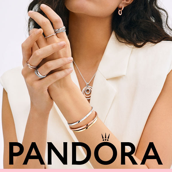 A woman wearing bracelets a necklace and rings from Pandora.