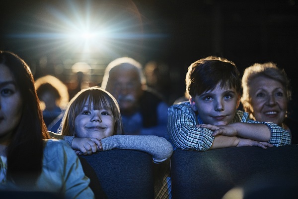 Photo of boy and girl in movie theatre watching a film